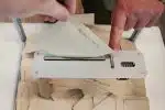 person holding white machine on top of white table