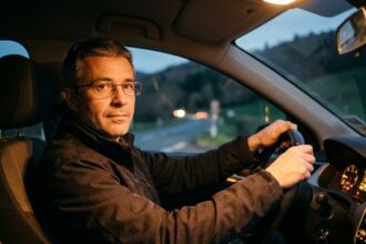 Conducteur portant des lunettes de correction au volant de sa voiture la nuit en Corrèze