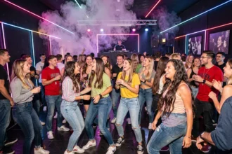 Groupe d'étudiants qui dansent dans une boite de nuit à Lille avec des lumières LED colorées et une ambiance festive