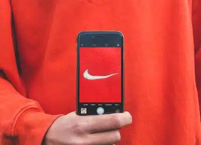 Une personne prend en photo avec son smartphone le logo Nike
