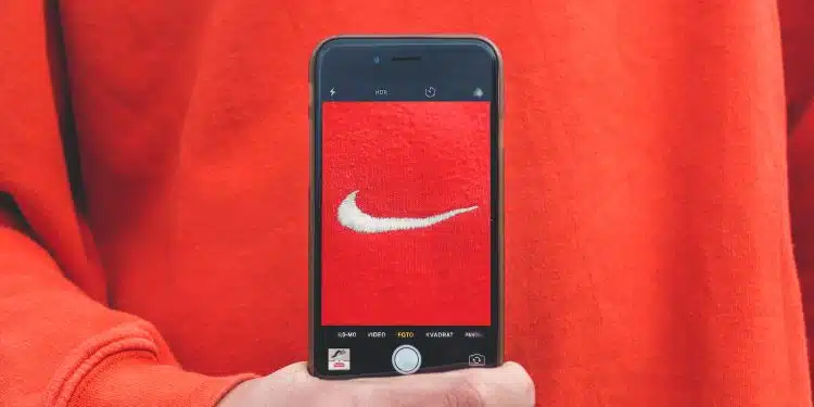 Une personne prend en photo avec son smartphone le logo Nike