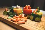 sliced carrots and green bell pepper on brown wooden chopping board