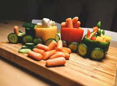 sliced carrots and green bell pepper on brown wooden chopping board