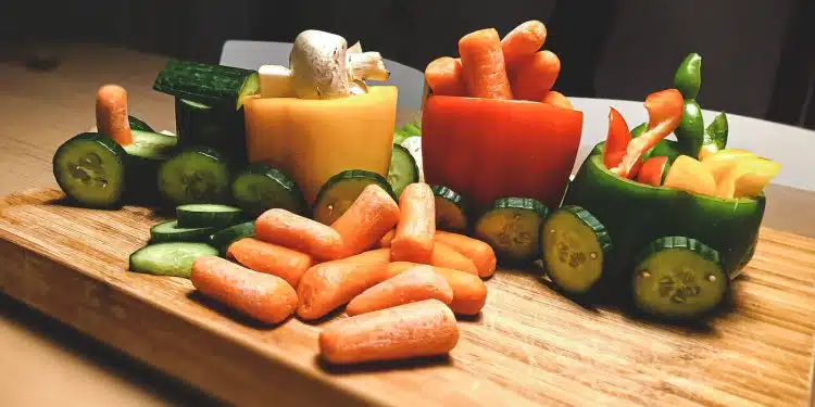 sliced carrots and green bell pepper on brown wooden chopping board